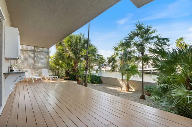 a view of a patio with a table and chairs next to a yard