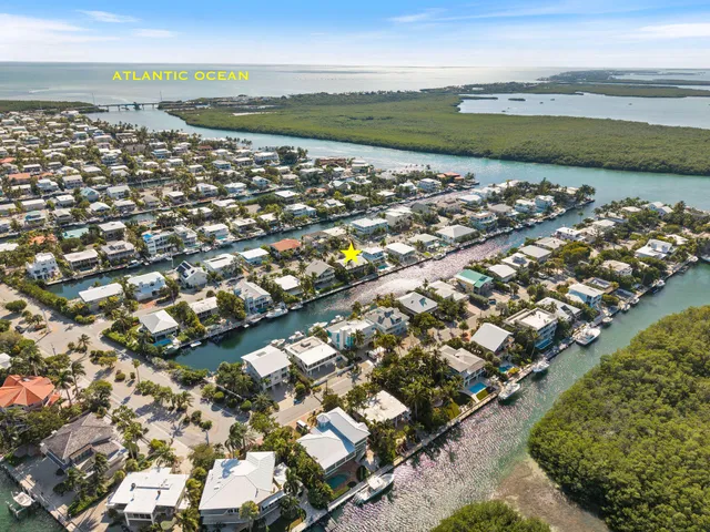 a front view of a house with a garden and lake view