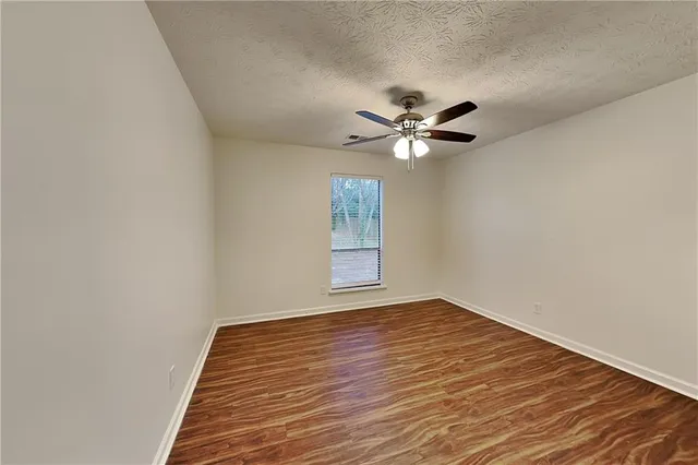 a view of room with wooden floor and ceiling fan