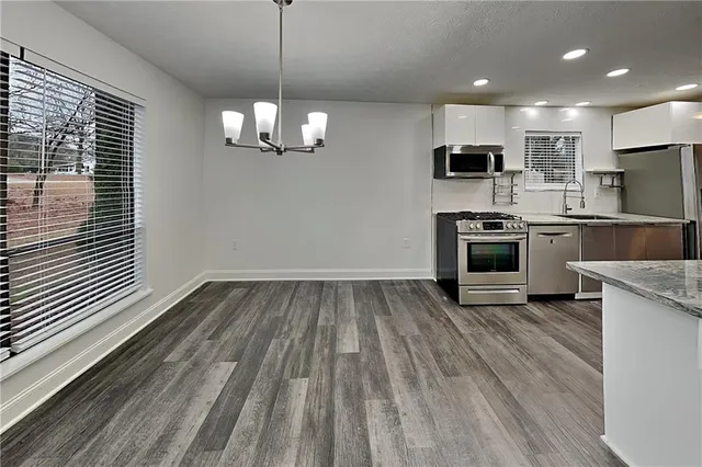 a view of kitchen with microwave stove refrigerator and cabinets