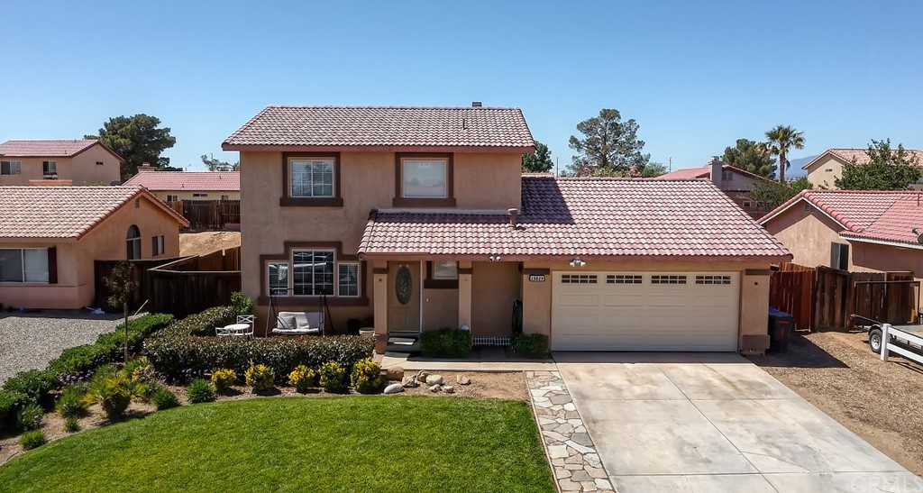 10829 Pepper Street Adelanto, CA 92301 - Photo 2 of 48 a front view of a house with a garden