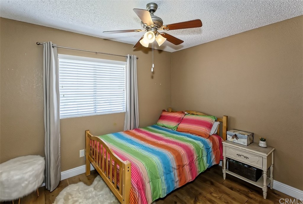 10829 Pepper Street Adelanto, CA 92301 - Photo 34 of 48 a bedroom with a bed and a chandelier