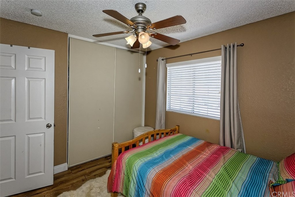 10829 Pepper Street Adelanto, CA 92301 - Photo 35 of 48 a bedroom with a bed and a chandelier