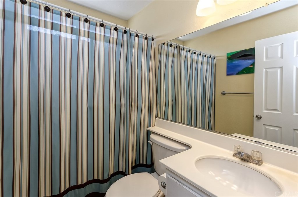 10829 Pepper Street Adelanto, CA 92301 - Photo 36 of 48 a bathroom with a sink a toilet and shower curtain