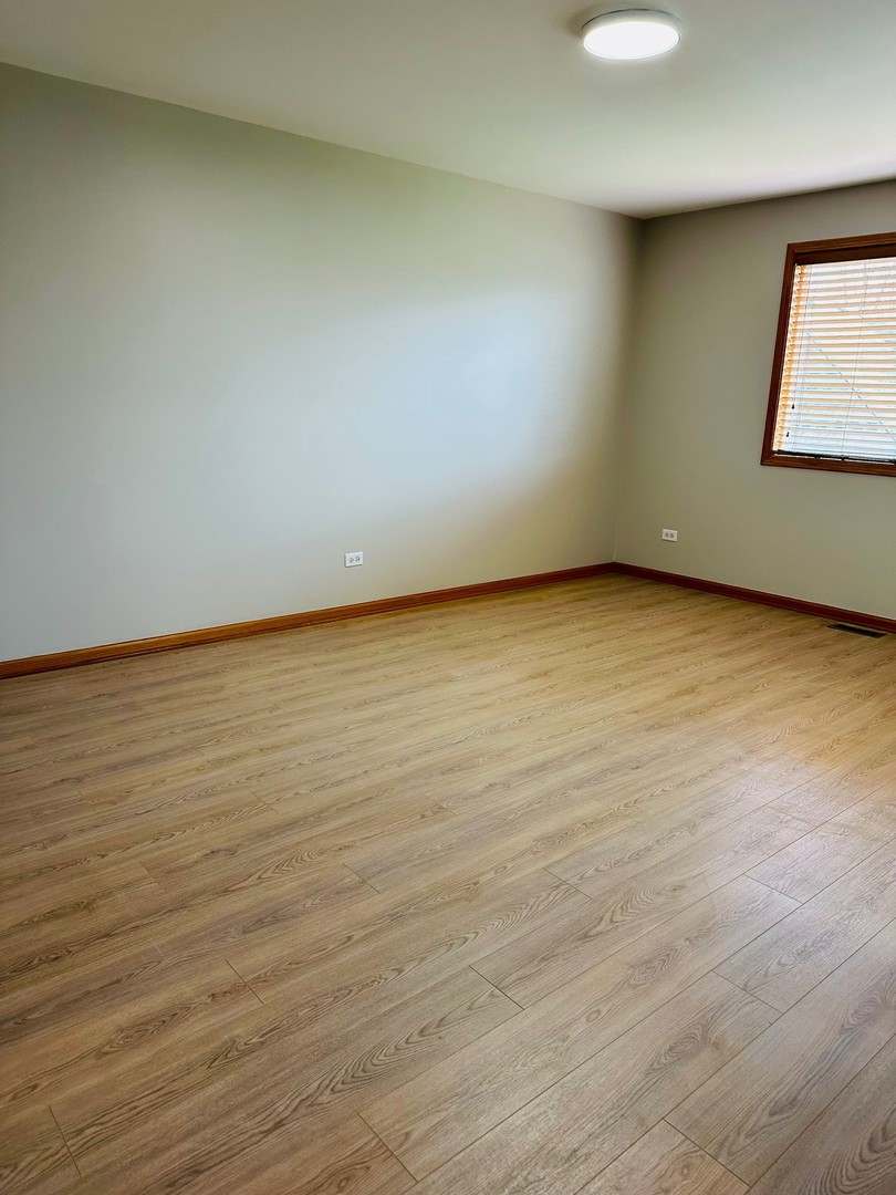 1805 Pebble Beach Drive Plainfield, IL 60586 - Photo 11 of 18 an empty room with wooden floor and windows