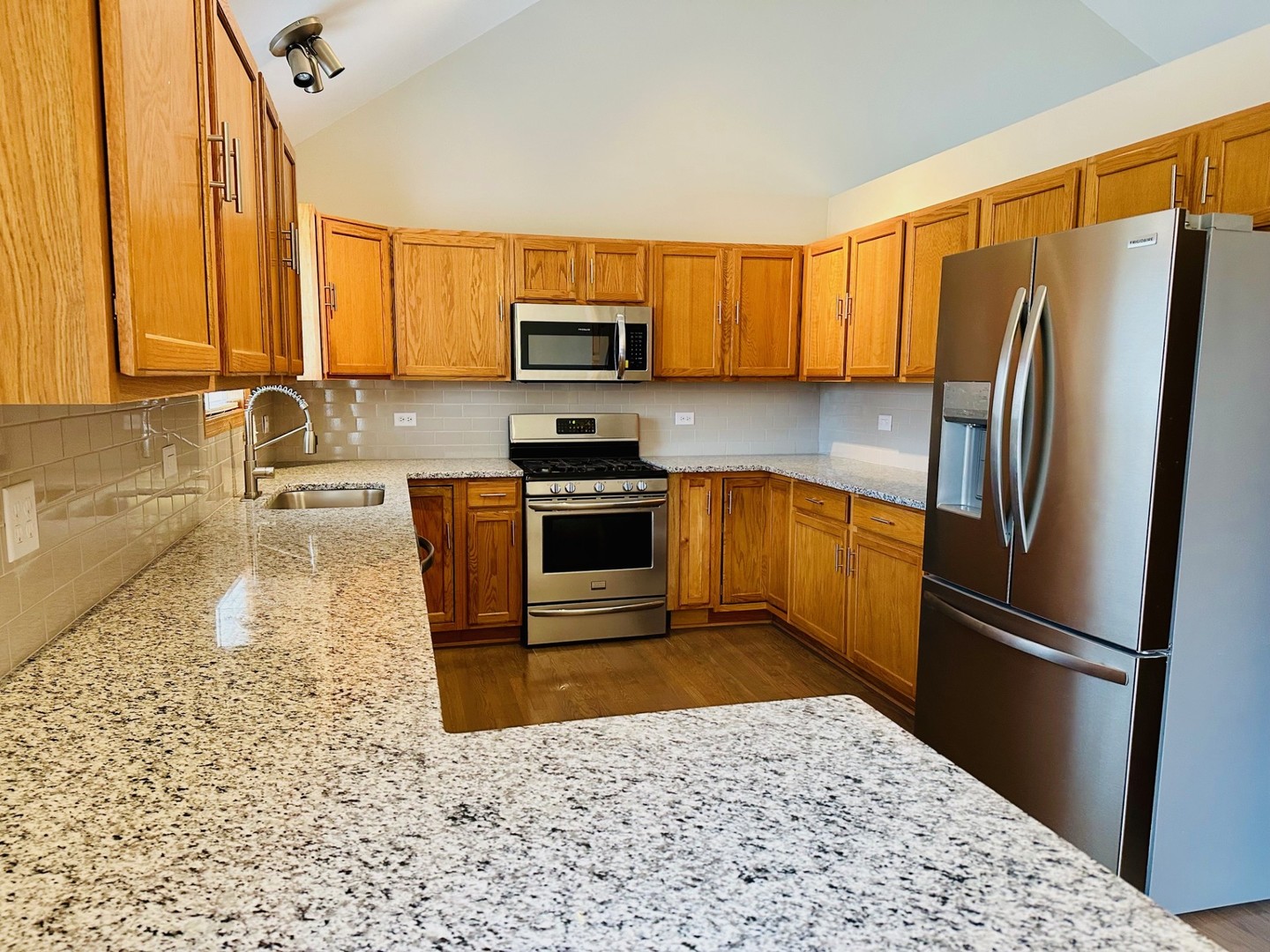 1805 Pebble Beach Drive Plainfield, IL 60586 - Photo 4 of 18 a kitchen with stainless steel appliances granite countertop a refrigerator stove top oven and sink