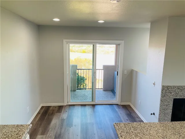an empty room with wooden floor and a fireplace