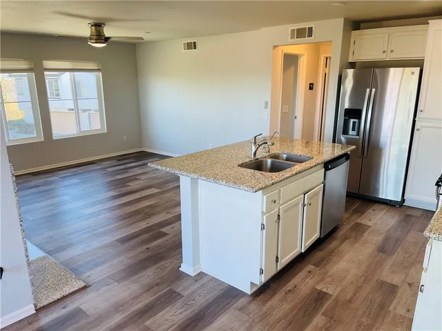 a kitchen with sink cabinets and wooden floor