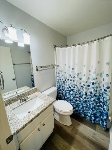 an empty room with wooden floor and a ceiling fan