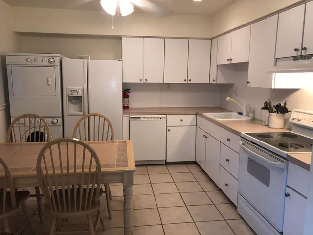 a kitchen with stainless steel appliances granite countertop a sink a stove a refrigerator and cabinets