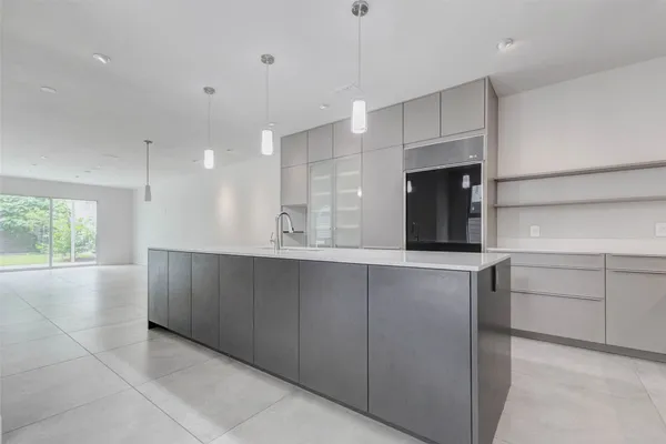 a view of kitchen with a sink wooden cabinets and window