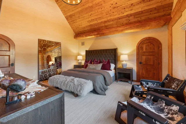 a bedroom with bed a mirror and a potted plant