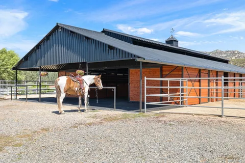 a backyard of a house with barbeque oven table and chairs