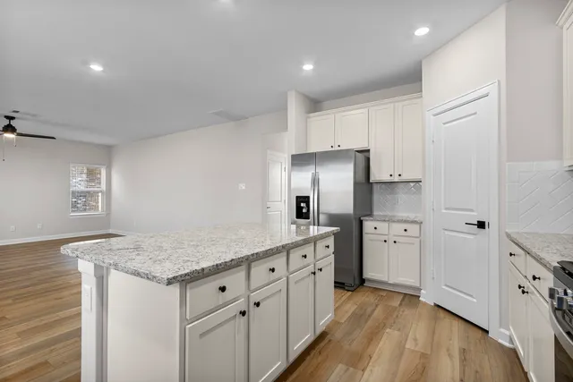 a kitchen with white cabinets a sink dishwasher and a refrigerator
