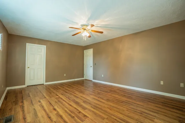 a view of empty room with wooden floor