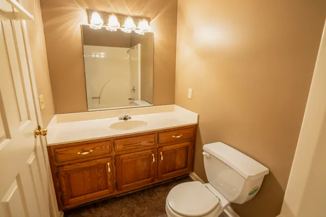 a bathroom with a sink a toilet and mirror