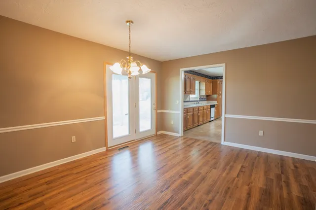 a view of a room with wooden floor staircase and a kitchen
