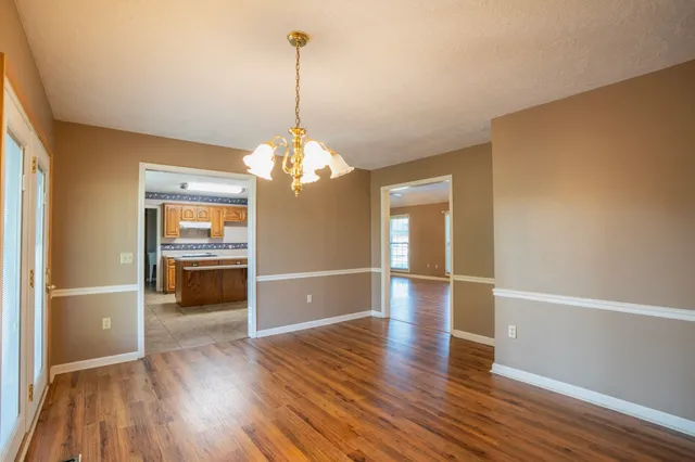 a view of a room with wooden floor and a ceiling fan