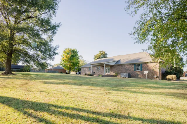 a view of a house with a big yard and palm trees