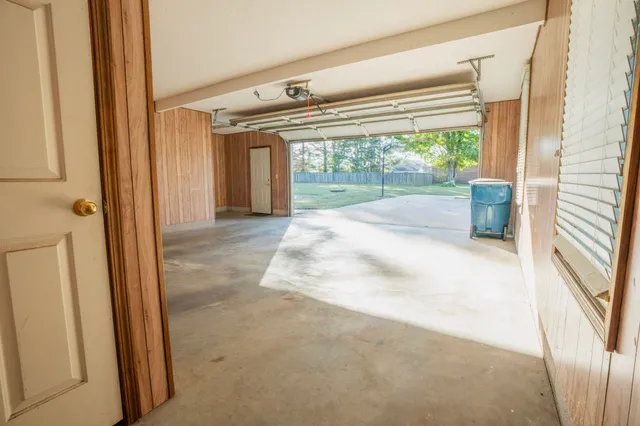 a view of a hallway with furniture and floor to ceiling window