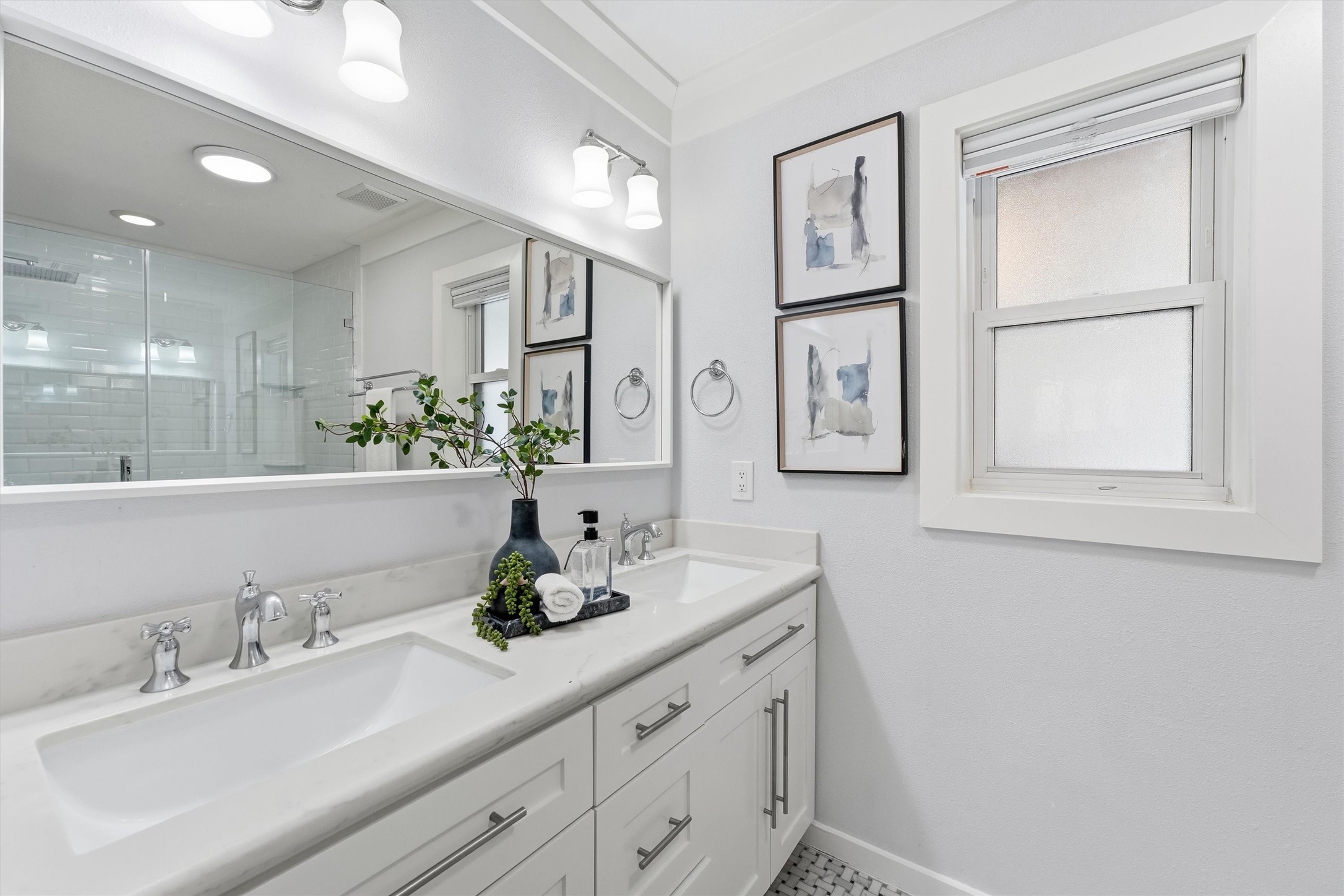 4701 Hummingbird Street Houston, TX 77035 - Photo 15 of 28 The primary bathroom was remodeled with double sinks, a quartz countertop, and chrome fixtures. With a basketweave marble floor tile and soothing color palate, this is the perfect place to start the day!