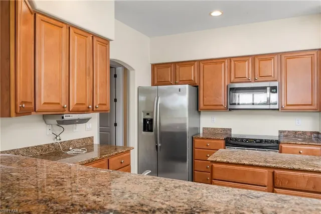 a kitchen with stainless steel appliances granite countertop a refrigerator and a sink
