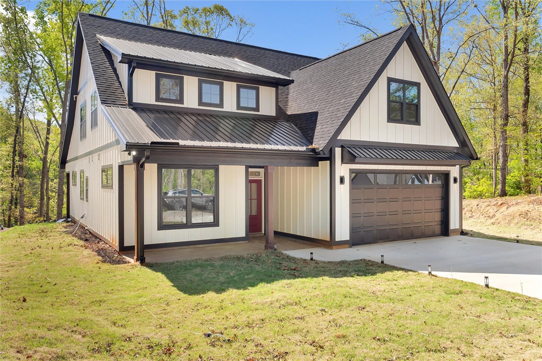 This modern farmhouse features striking black and white siding with a durable metal roof.