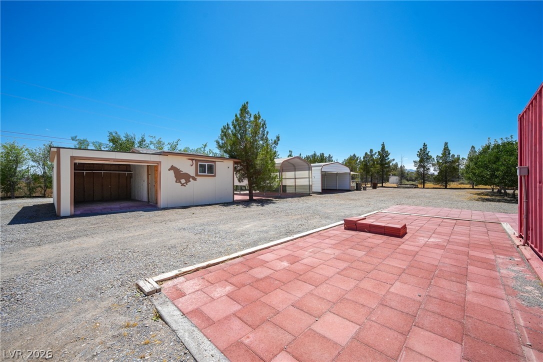 1831 West Horn Road Pahrump, NV 89048 - Photo 42 of 59 A spacious, open area offers multiple outbuildings for versatile use under an open sky.