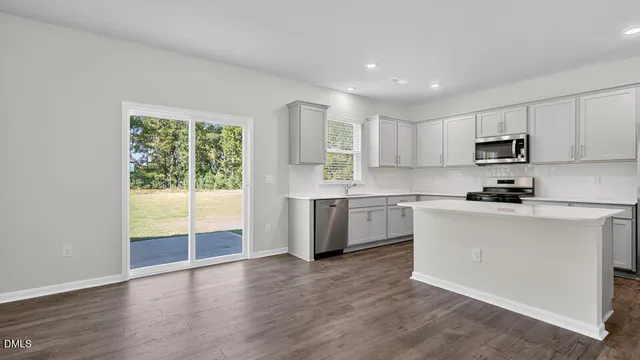 a kitchen with a sink a counter top space stainless steel appliances and a window