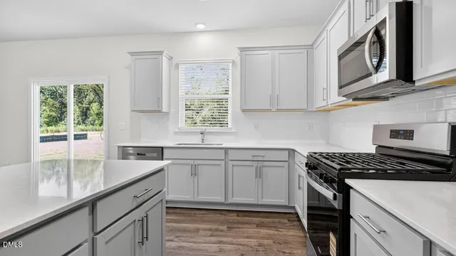 a kitchen with stainless steel appliances granite countertop a stove a sink and a granite counter tops