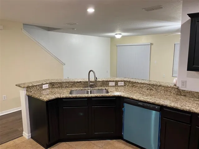 a kitchen with a sink a counter space and wooden floor