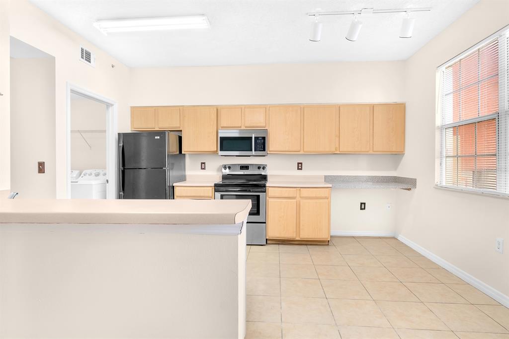 10873 Windsor Walk Drive, Unit 4106 Orlando, FL 32837 - Photo 8 of 30 a kitchen with a refrigerator and a stove top oven