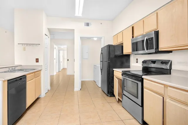 a kitchen with stainless steel appliances granite countertop a refrigerator and a stove top oven