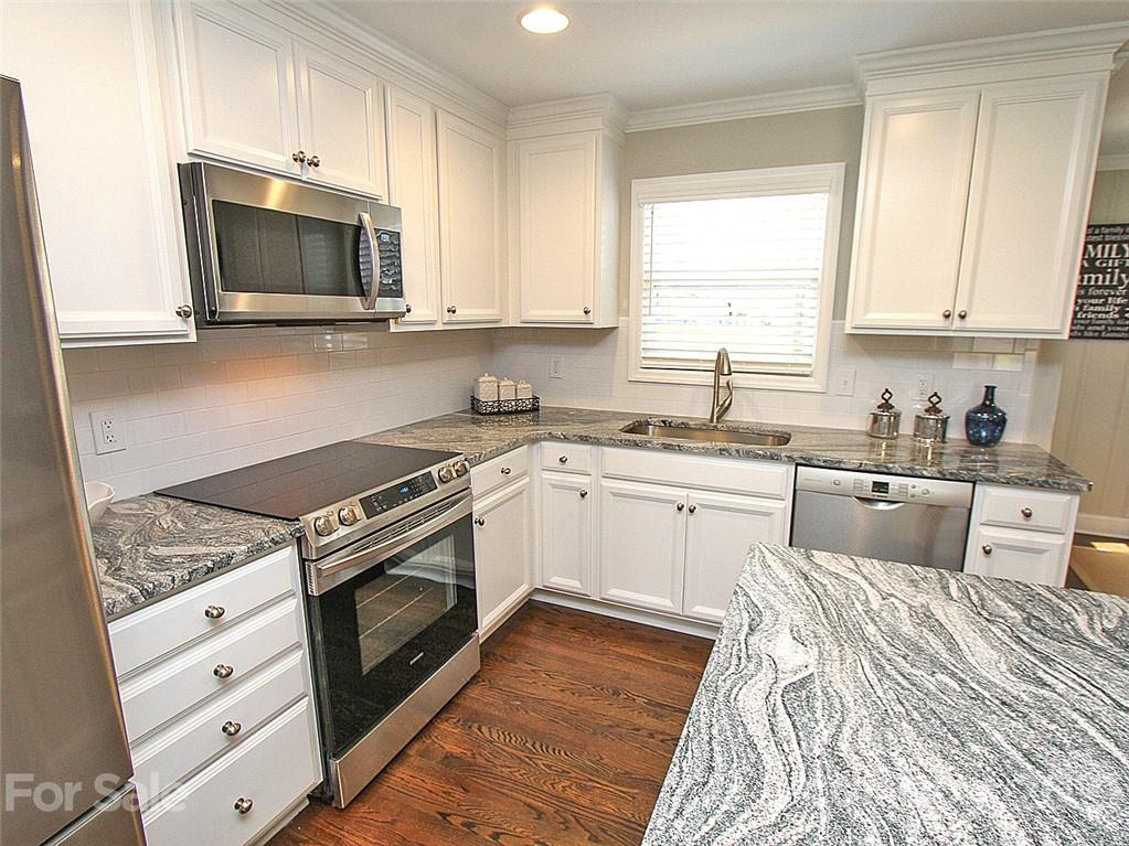 405 Fieldstone Road Mooresville, NC 28115 - Photo 3 of 46 a kitchen with granite countertop white cabinets and white appliances