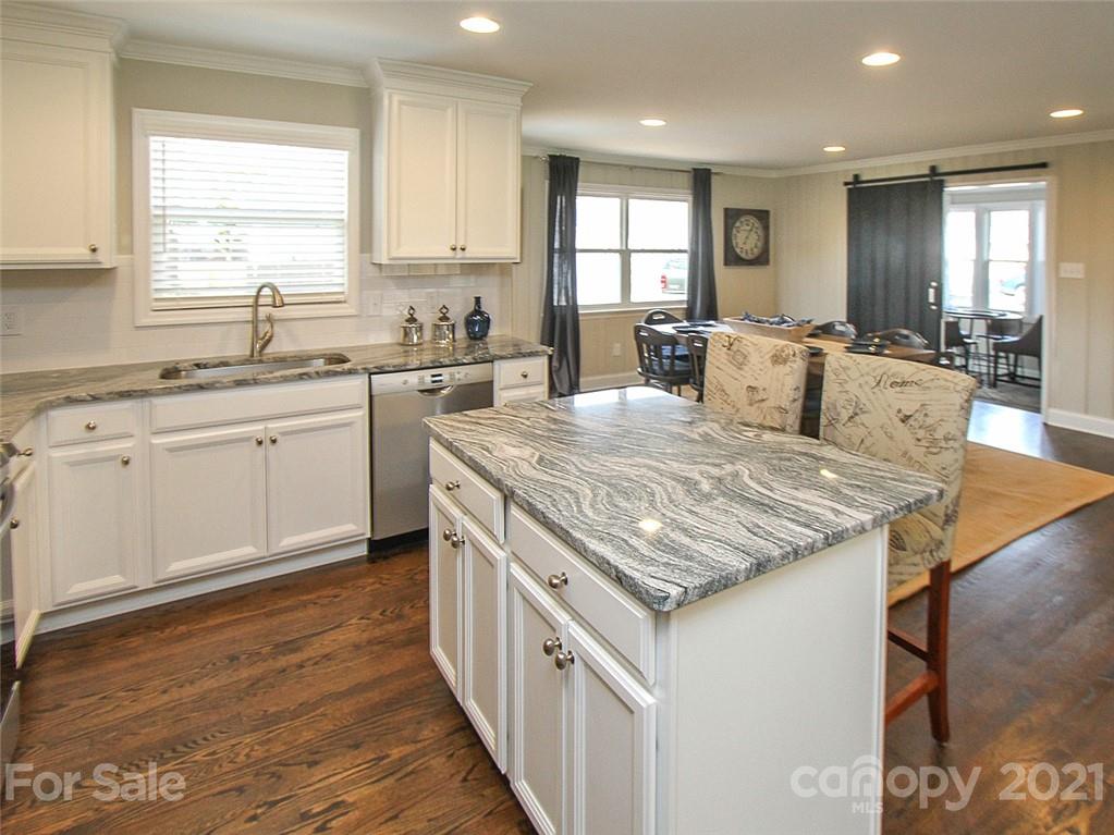 405 Fieldstone Road Mooresville, NC 28115 - Photo 5 of 46 a open kitchen with granite countertop a sink and white cabinets with wooden floor