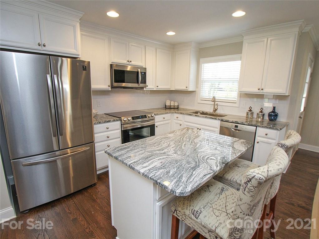 405 Fieldstone Road Mooresville, NC 28115 - Photo 7 of 46 a kitchen with granite countertop stainless steel appliances and wooden cabinets