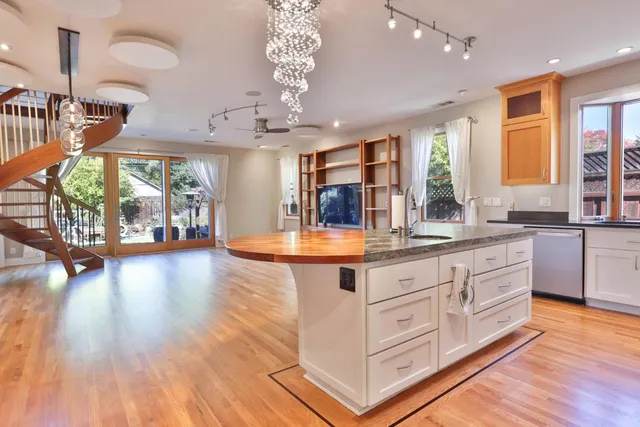 a large kitchen with stainless steel appliances granite countertop a lot of counter space and wooden floors