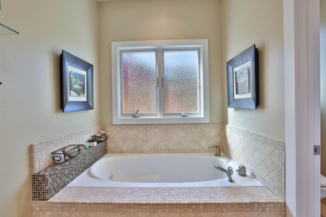 a bathroom with a tub and mirror