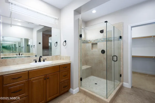 a bathroom with a shower sink and mirror