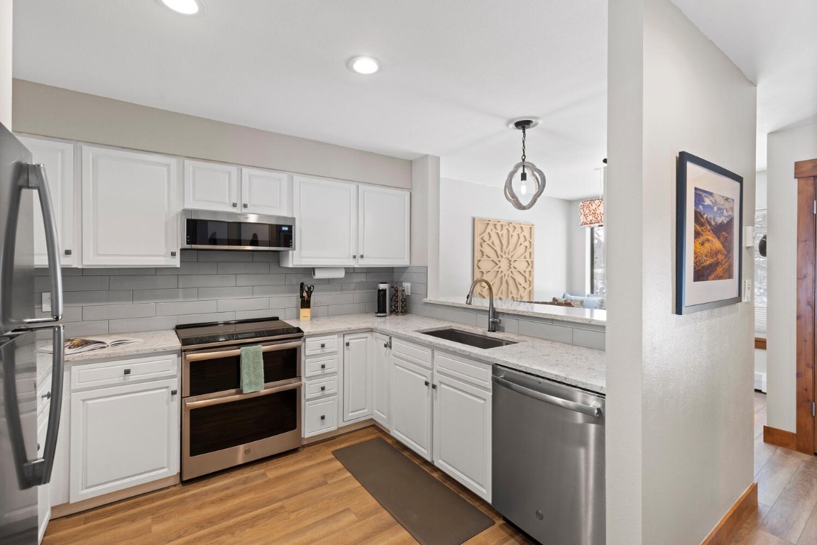 1928 Soda Ridge Road, Unit 1226 Keystone, CO 80435 - Photo 12 of 34 a kitchen with cabinets stainless steel appliances and wooden floor