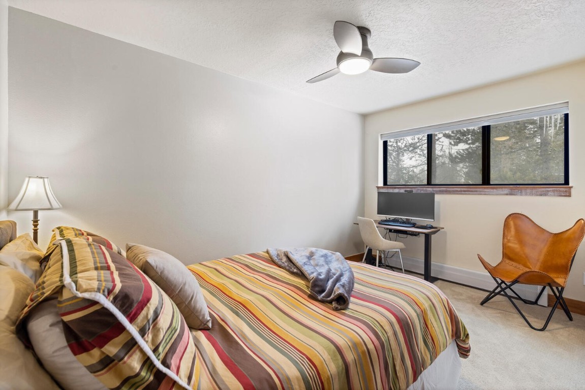 1928 Soda Ridge Road, Unit 1226 Keystone, CO 80435 - Photo 27 of 34 a bedroom with a bed a chair and a chandelier