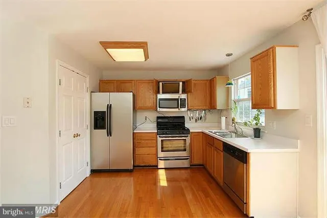 a kitchen with stainless steel appliances a refrigerator sink and stove