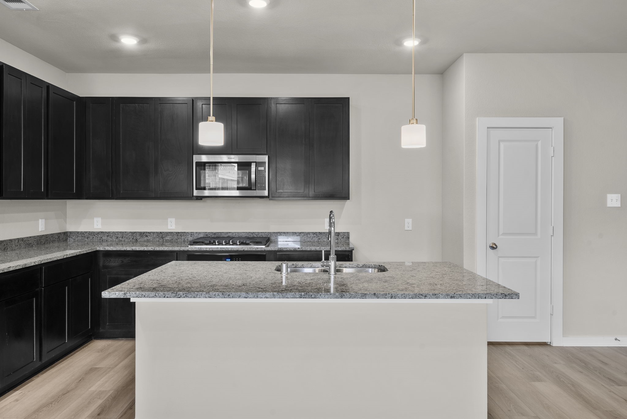 1911 Stargazer Lane Angleton, TX 77515 - Photo 4 of 33 a kitchen with granite countertop a stove a sink and a microwave