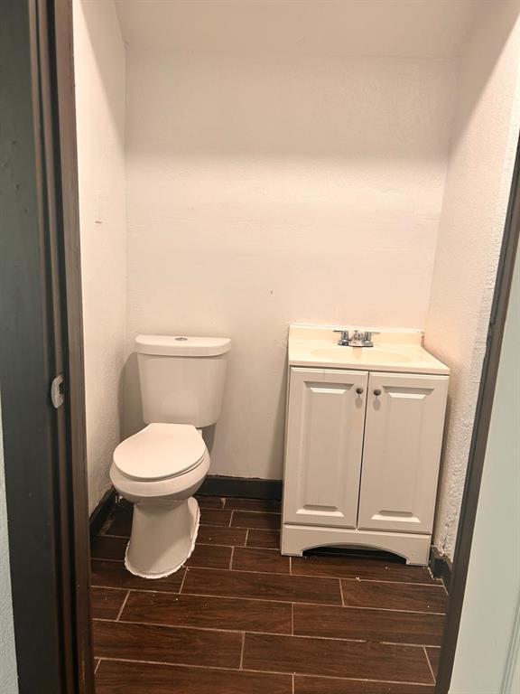 2710 Mitchell Street Dallas, TX 75210 - Photo 13 of 15 Half bathroom featuring vanity, wood tiled floors, and a textured wall