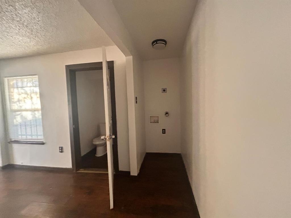 2710 Mitchell Street Dallas, TX 75210 - Photo 14 of 15 Hallway with a textured ceiling and dark wood-style flooring