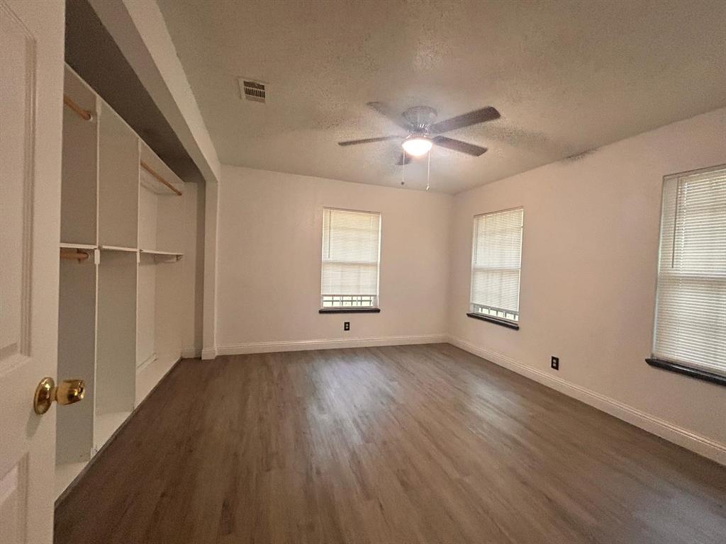 2710 Mitchell Street Dallas, TX 75210 - Photo 7 of 15 Unfurnished bedroom with a textured ceiling, dark wood-type flooring, and ceiling fan