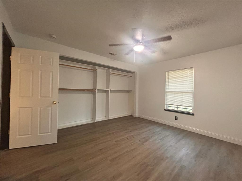 2710 Mitchell Street Dallas, TX 75210 - Photo 8 of 15 Unfurnished bedroom with dark wood-type flooring, a textured ceiling, a closet, and ceiling fan