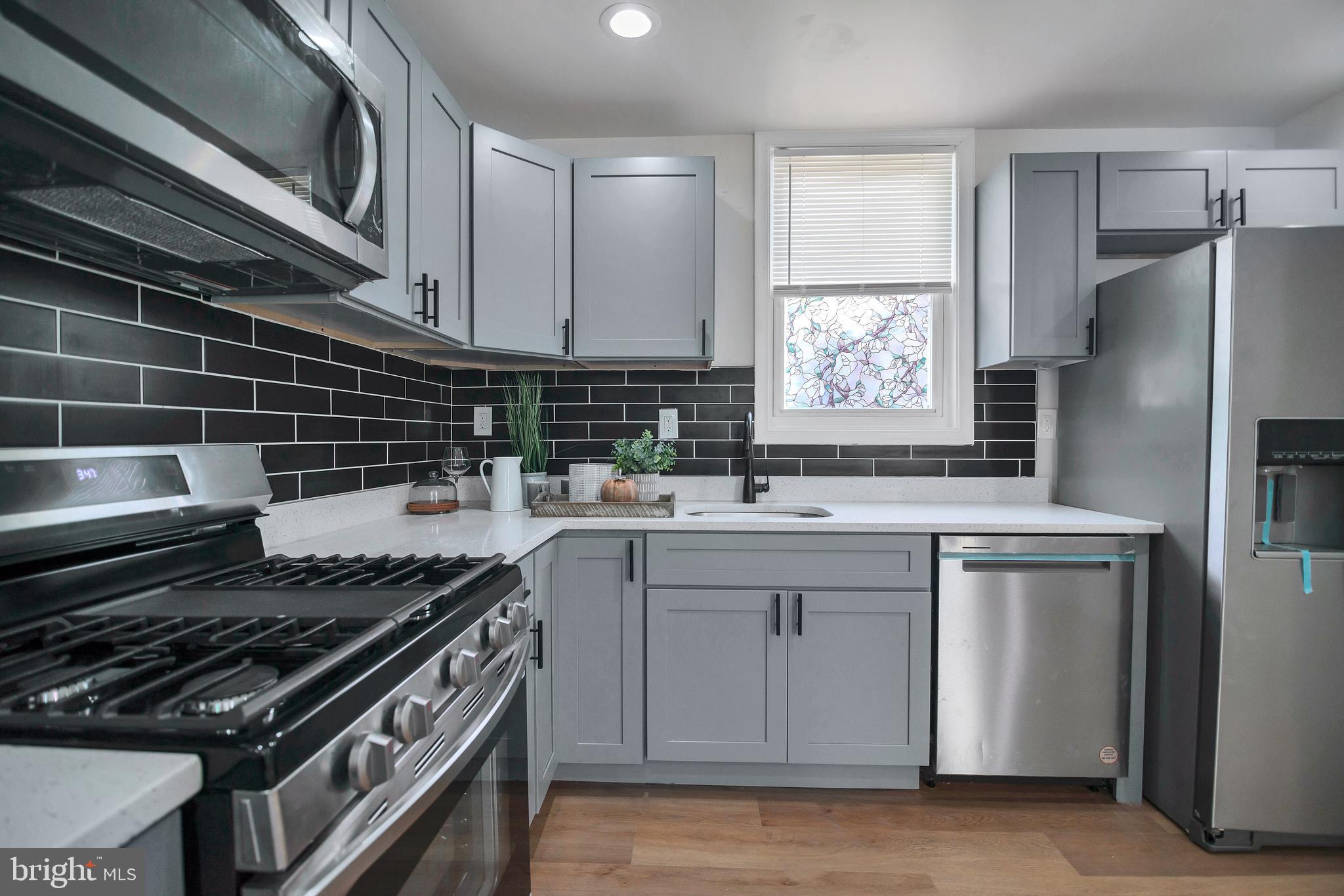 4132 Marx Avenue Baltimore, MD 21206 - Photo 19 of 76 a kitchen with stainless steel appliances a stove a sink and white cabinets