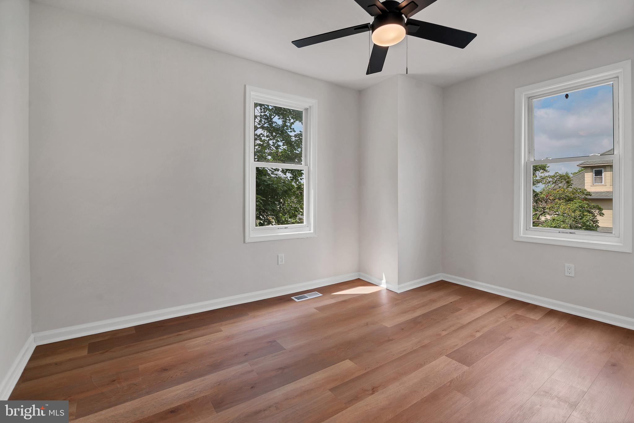 4132 Marx Avenue Baltimore, MD 21206 - Photo 33 of 76 an empty room with wooden floor chandelier fan and windows