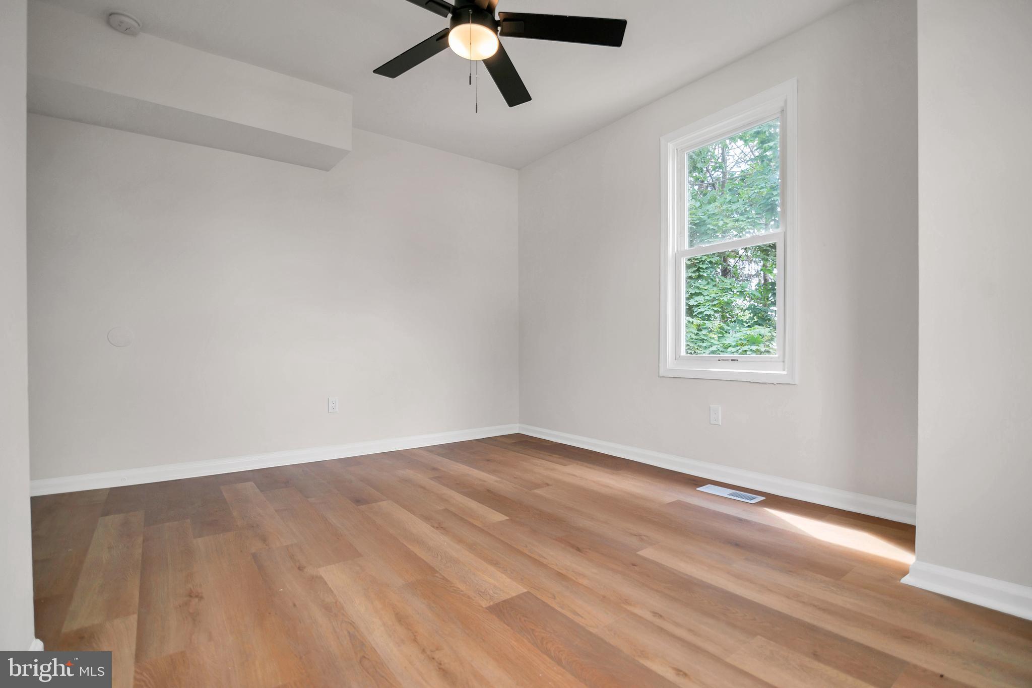 4132 Marx Avenue Baltimore, MD 21206 - Photo 35 of 76 an empty room with a window and a ceiling fan